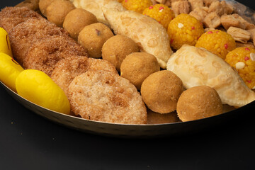 Indian sweets in a plate includes anarsa, shakkarpara morichoor  Bundi Laddu, Gujiya or Karanji for diwali celebration