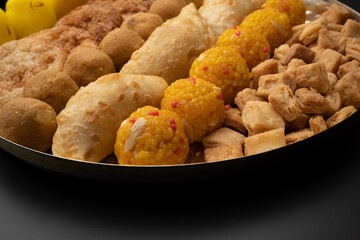 Indian sweets in a plate includes anarsa, shakkarpara morichoor  Bundi Laddu, Gujiya or Karanji for diwali celebration