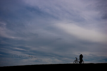 Radfahrer vor weitem Himmel