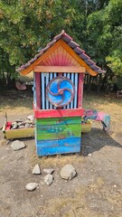 Obraz premium Colorful outdoor shrine with religious iconography in a natural setting