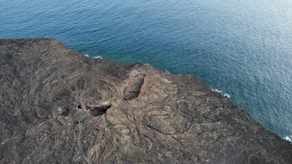 Solidified lava flow meeting the ocean on volcanic coastline