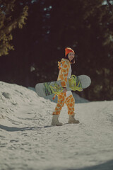  A girl with a snowboard in her hands against the backdrop of snowy mountains