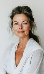 Fototapeta premium Woman with grey hair smiles in white shirt.