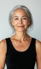 Fototapeta premium Smiling woman with gray hair wearing black tank top.