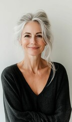 Smiling woman with gray hair wearing a black sweater.
