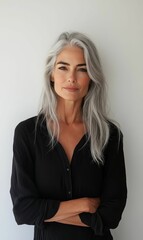 Woman with long gray hair, black shirt, arms crossed.