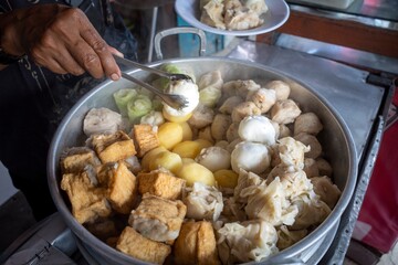 Siomay, fish cake dumplings with potato, rolled cabbage, and egg served with peanut sauces