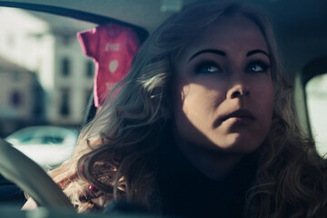 Blonde woman driving vintage car exploring european city