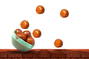 Gulab jamun falling from green bowl. Traditional Indian dessert on wooden table with copy space for ads.