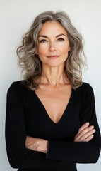 Obraz premium Woman with gray hair, black shirt, arms crossed.