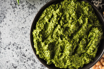 Homemade Pesto Sauce with Pine Nuts and Basil: Ingredients on Black Background