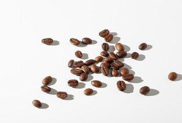 Roasted coffee beans scattered on a white background