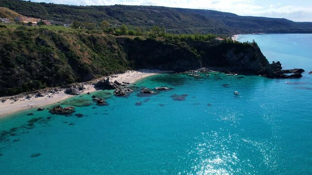 4K Aerial drone video of one of the most beautiful beaches in the world with turquoise clear blue water and white sand with big rocks on a sunny summer day. Marinella di Zambrone Paradiso Tropea Italy