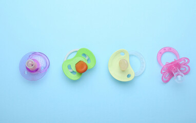 Newborn baby's pacifiers on a blue background. Top view