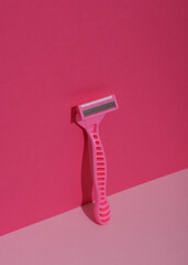 Вisposable razor on pink background. Creative layout. Minimalism