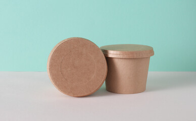 Eco cardboard round food box on table, mint green background