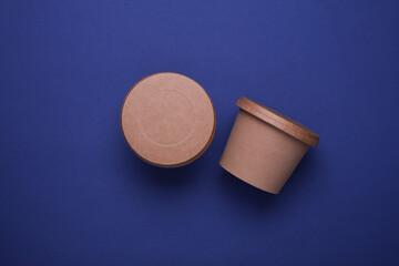 Eco cardboard round food boxes on blue background. Top view