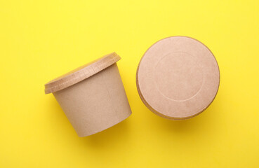Eco cardboard round food boxes on yellow background. Top view
