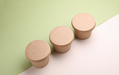 Eco cardboard round food boxes on green beige background. Top view