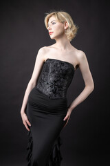Fototapeta premium Expressive young blonde under a bob in the studio. In a black corset and dress.
