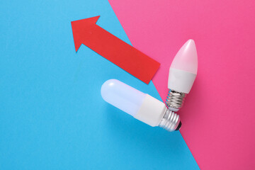 LED bulbs with growth arrow on blue pink background