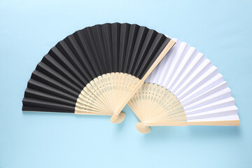 Traditional black Asian hand fans on blue background