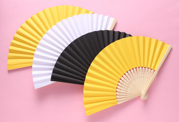 Traditional Asian hand fans on pink background.