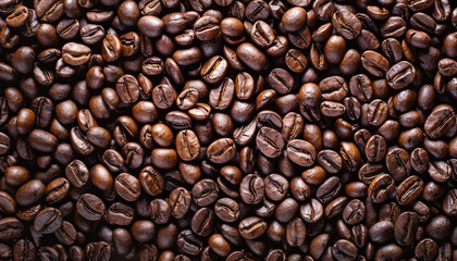 Fototapeta premium Close up of coffee beans with a lot of them in the foreground. The beans are brown and have a lot of detail
