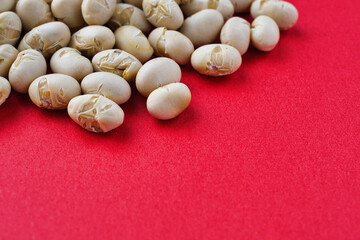 日本の節分：節分豆  (節分の豆)　赤背景　コピースペースあり　背景素材　Japanese Setsubun: Setsubun beans on a red background with copy space, Background material