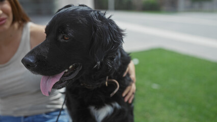 A young woman with a beautiful labrador dog enjoys an outdoor afternoon in an urban park within the city.