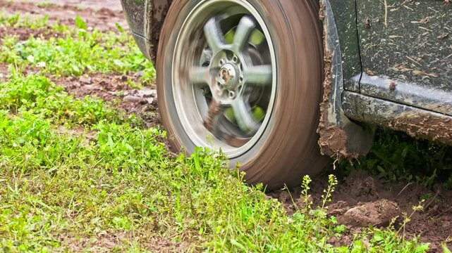 car tire slipping while stuck in a dirt, heating up and steaming in attempt to get free, closeup with selective focus