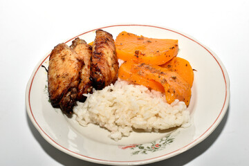 Healthy and filling breakfast. Stewed pumpkin, boiled rice and grilled chicken wings.