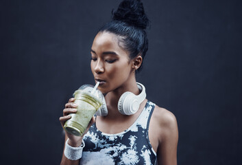 Woman, headphones and green healthy smoothie for diet, nutrition and energy with kale, organic...