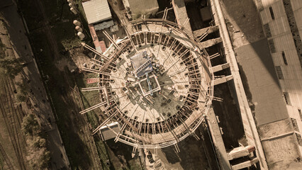 Construction site of a power plant a high chimney.Dangerous work at height.A renovation is smokestack.Contractor repairing a chimney at a highrise.Workers in a hard hat.Dangerous work at the daytime.