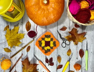 Autumn composition with crocheting, pumpkin, leaves, scissors and clews and hooks fall vibe cozy...