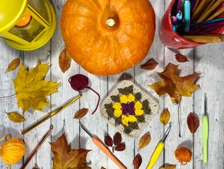 Autumn composition with crocheting, pumpkin, leaves, scissors and clews and hooks fall vibe cozy home photo 