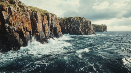 Obraz premium A rocky coastline on an island, with waves crashing dramatically against the cliffs.