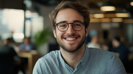 Obraz premium Smiling young business professional with glasses, involved in an office meeting, showcasing a collaborative work atmosphere.