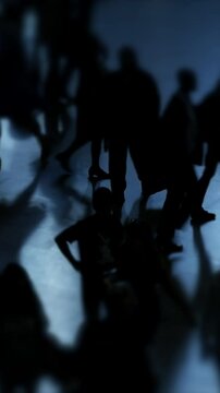 Silhouettes of Various People Walking in a Dimly Lit Space, Evoking Curiosity and Emotion