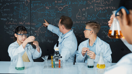 Smart teacher explain about chemical theory while student mixing colored solution or doing...