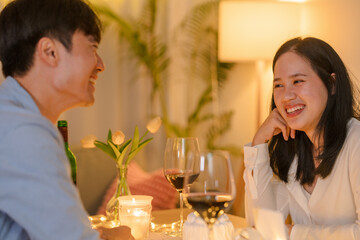 Young couple having fun drinking red wine in living room at home Attractive friends man and woman feeling happy and relax having a  drink with glass of wine to celebrating event.