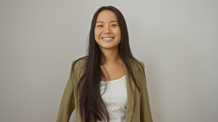 Young chinese woman smiling over an isolated white background wearing a green jacket and white top