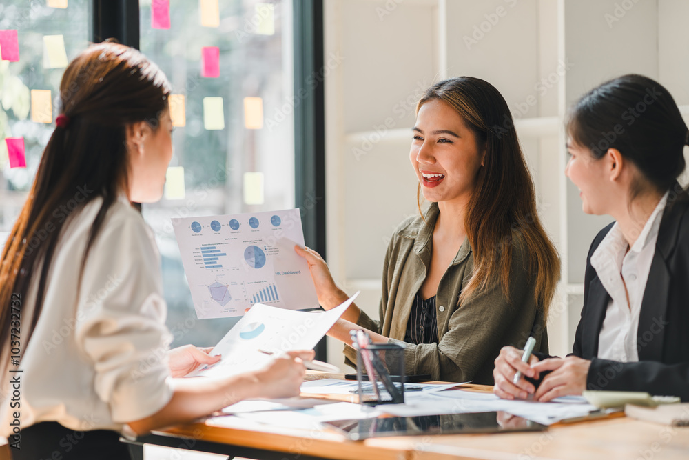 Wall mural group of three women engaged in business meeting, discussing charts and graphs with enthusiasm. setting is bright and modern, reflecting collaborative atmosphere