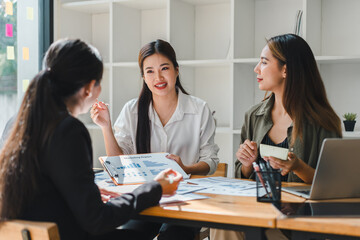 Professional women engaged in business meeting, discussing marketing strategies and analyzing reports. atmosphere is collaborative and focused, showcasing teamwork and communication