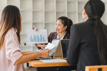 Obraz premium Engaged business meeting with woman presenting data charts to colleagues, showcasing teamwork and collaboration in modern office setting