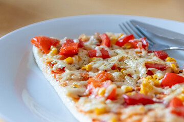 Authentic delicious slice of vegetarian pizza for healthy lifestyle of vegetarians and vegans with fast food snack as piece of pizza with paprika and sweet corn and cheese topping as delicious snack