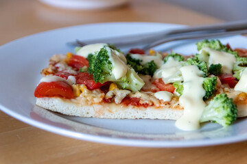 Authentic delicious slice of vegetarian pizza for healthy lifestyle of vegetarians and vegans with fast food snack as piece of pizza with broccoli and paprika and sweet corn and cheese topping snacks