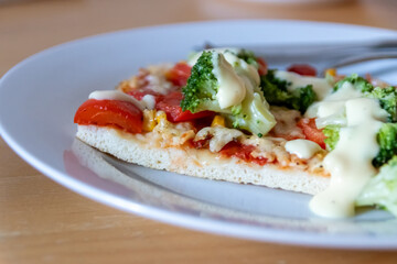 Authentic delicious slice of vegetarian pizza for healthy lifestyle of vegetarians and vegans with fast food snack as piece of pizza with broccoli and paprika and sweet corn and cheese topping snacks