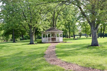 The white gazebo in the park on a sunny day.