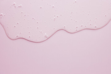Liquid cosmetic minimal pink background, flowing gel texture, dripping jelly cream or face serum...